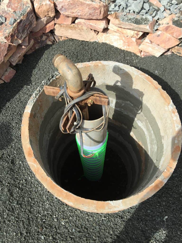 Borewell casing with slits and mesh wrapping